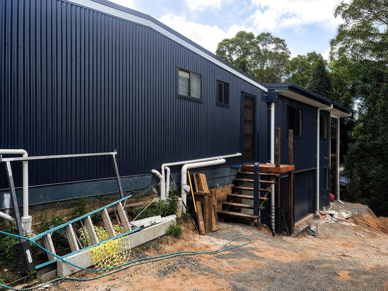 Dark-clad residential addition on a sloping site.